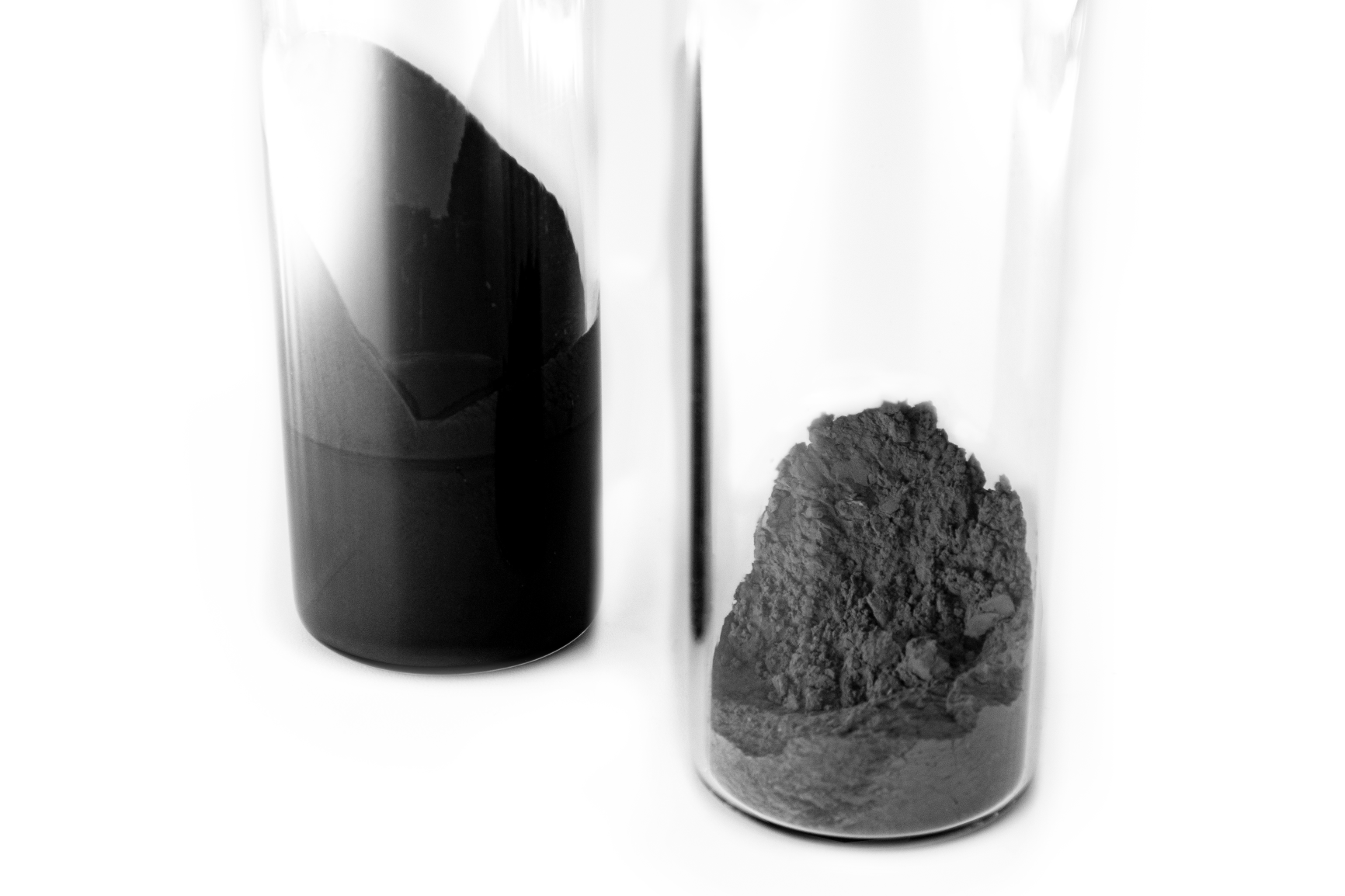 Both MR (magnetorheological) fluid and powder in a glass cylinder in their unlinked (liquid/powdered) state.