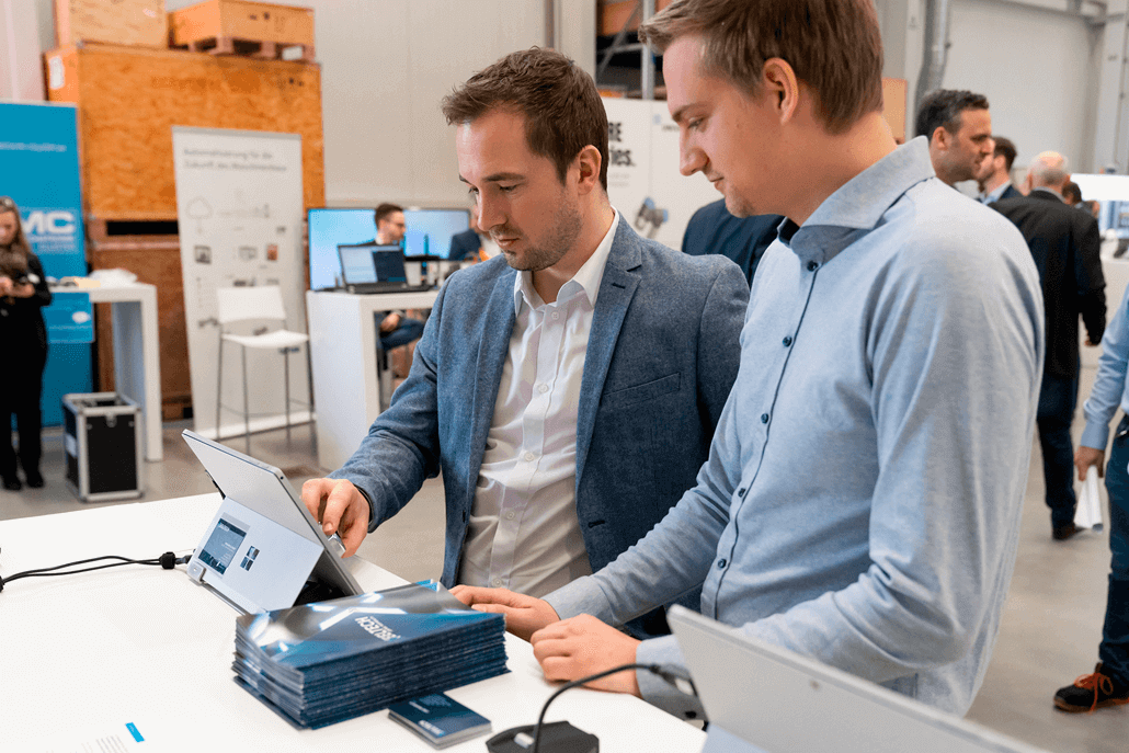 Photo of our HAPTICORE customer support team member introducing a visitor at the XeelTech booth to our rotary haptic feedback actuatos.