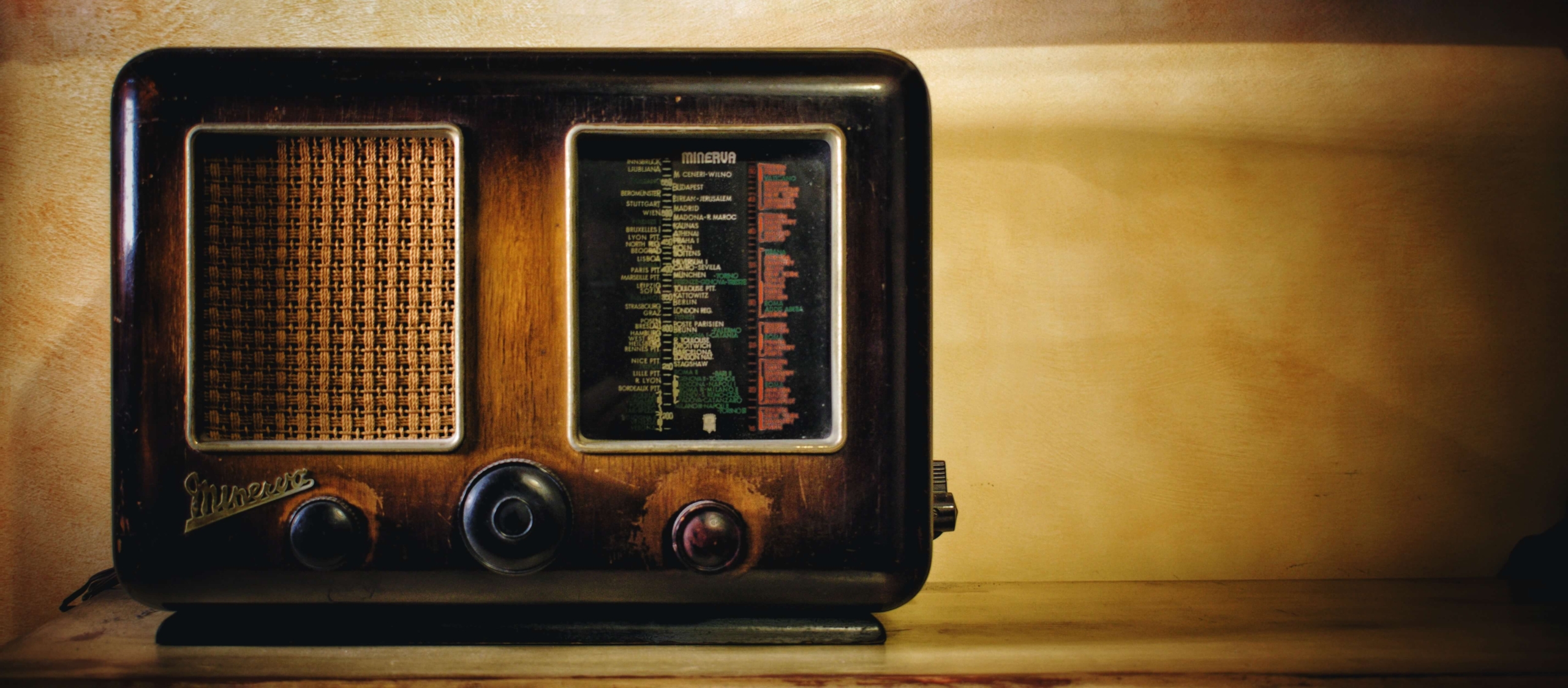 A wodden vintage radio with rotary knobs to tune both volume and frequence.